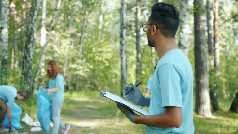 Volunteers collect litter in a forest, showcasing teamwork and environmental care.