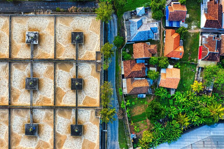 Aerial photograph depicting an industrial plant next to a residential neighborhood in Indonesia.