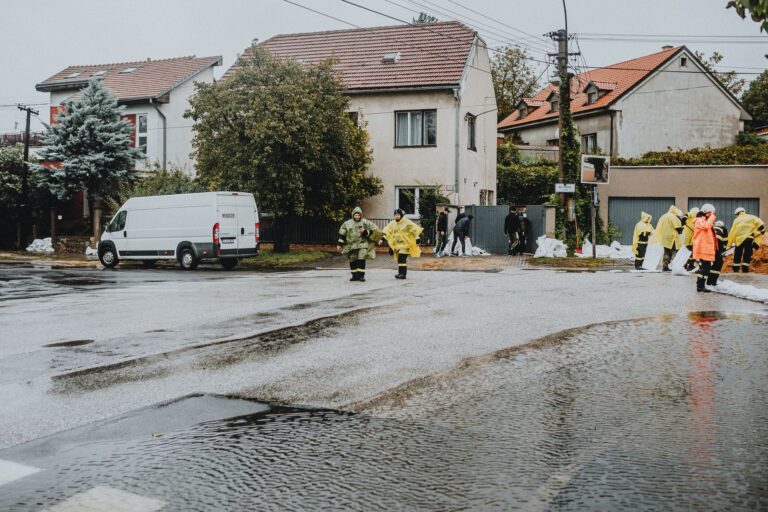 Emergency response team members handle city flooding, deploying sandbags and wearing gear.