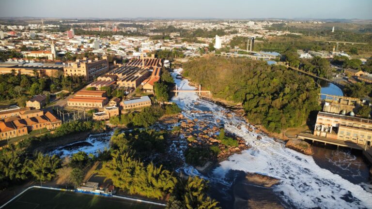 Aerial view of a river flowing through a city near industrial buildings.